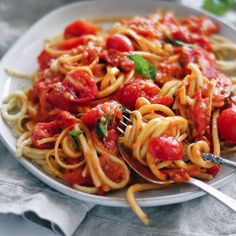 a white plate topped with spaghetti and tomato sauce