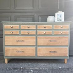 an old dresser is painted gray and wood