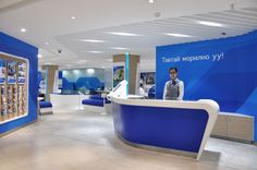 a man standing in front of a blue and white reception counter at a hotel lobby