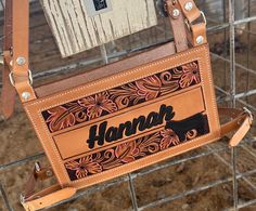 a handbag with the name hannah on it hanging from a wire fence in front of a building