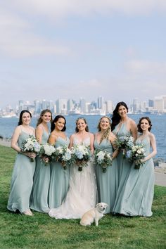 a group of women standing next to each other on top of a grass covered field