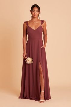 a bridesmaid in a long, spaghetti - neck dress with slits on the side