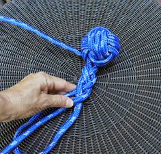 a hand holding a blue rope on top of an umbrella