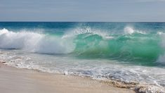 the ocean waves are crashing on the beach