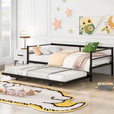 a child's bedroom with white walls and wood flooring, including a black daybed