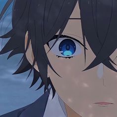 an anime character with black hair and blue eyes looks at the camera while staring into the distance