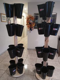 there are many black cups on the floor in front of each other and one has a stick sticking out of it