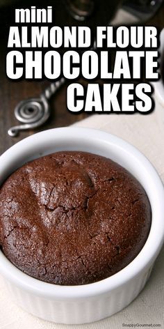 a close up of a cake in a bowl on a table with the words, mini almond flour chocolate cakes