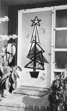 a black and white photo of a door with a christmas tree drawn on the front