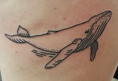 a whale tattoo on the back of a woman's thigh