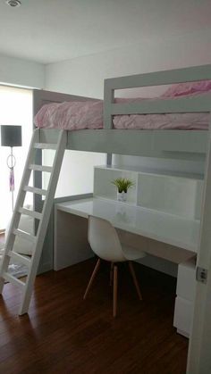 a loft bed with desk underneath it and ladder to the upper level, next to a window