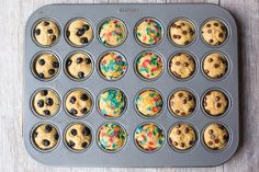 a muffin tin filled with cupcakes topped with frosting and sprinkles