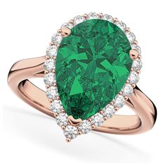 a pear shaped emerald and diamond ring in yellow gold with diamonds around the band, on a white background