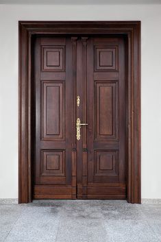 two wooden doors are open in front of a white wall and grey tile flooring