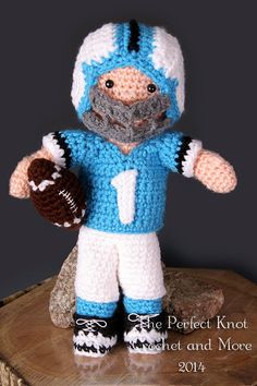 a crocheted blue and white football player doll with a ball in his hand