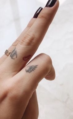 two fingers with small tattoos on them