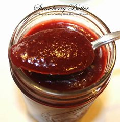 a spoon full of jam sitting in a jar