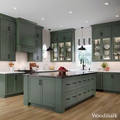 a kitchen with green cabinets and wooden floors