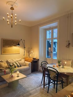 a living room filled with furniture next to a table and two chairs in front of a window