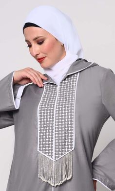 Elevate your modest fashion with our Hoodie Abaya, where contemporary style meets traditional elegance. Crafted from high-quality fabric, this abaya features intricate check embroidery, adding a touch of sophistication. The front is adorned with charming tassels that sway gracefully with your movements, creating a dynamic silhouette. Designed for both comfort and style, it includes two practical pockets, perfect for keeping essentials close at hand. Whether worn casually or for special occasions, this Hoodie Abaya promises to be a versatile and timeless addition to your wardrobe. Size & FitModel height is 5’9’’ and is wearing a Small size Material & CareMaterial: Slub PoplinCare: Gentle machine wash in cold water or Drycleaning SpecificationsSleeve Length: Full SleevesLength: Ankle Length Casual Long Sleeve Abaya With Modesty Panel, Casual Winter Abaya, Modest Long Sleeve Thobe With Modesty Panel, Modest Long Sleeve Gray Abaya, Casual Long Sleeve Abaya For Eid, Hoodie Abaya, Abaya With Pockets, Check Embroidery, Grey Hoodie