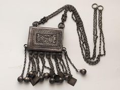 A statement Omani necklace typical of Omani jewelry from Nizwa in the north. This is a hirz necklace which is meant to be a Koran box or holder. A hirz necklace was worn all over Oman by children and adults alike, though children's necklaces were smaller. Verses of the Koran were hidden in the secret component and were thought to keep the wearer safe.   The rectangular box is decorated with repousse motifs and a total of 8 pairs of diamond-shaped and bell-shaped dangles hanging from chains. The Kids Necklace, Museum Collection, Diamond Shaped, British Museum, Oman, Diamond Shapes, Vintage Silver, Halloween Shopping, Beautiful Jewelry