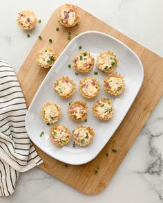 small appetizers on a white plate with a striped dish towel next to them