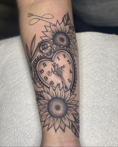 a woman's arm with a clock and sunflower tattoo on it