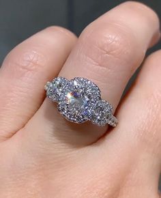 a woman's hand with a diamond ring on top of her finger and an engagement band in the middle