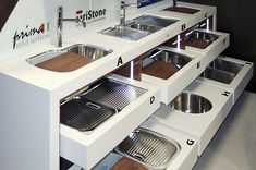 a kitchen with two sinks and drawers under the faucet in front of it