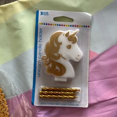 a white and gold unicorn head brooch sitting on top of a package