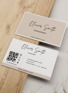 two business cards sitting on top of a wooden table