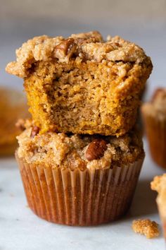 two muffins stacked on top of each other with crumbs around them