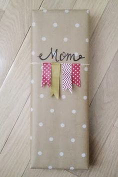 an image of a gift wrapped in brown paper with pink and yellow bows on it