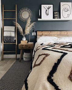 a bedroom with blue walls and pictures on the wall above the bed, along with a ladder