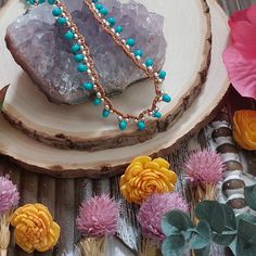 a piece of wood sitting on top of a table next to flowers and other items