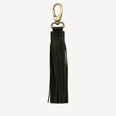 a black leather keychain with a gold metal hook and tassel on it