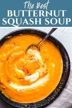 the best butternut squash soup is in a black bowl with a spoon inside it