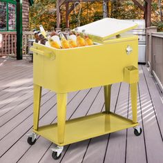 a yellow cooler filled with drinks on top of a wooden deck