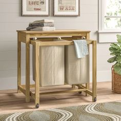 a wooden table with two towels on it and a potted plant next to it