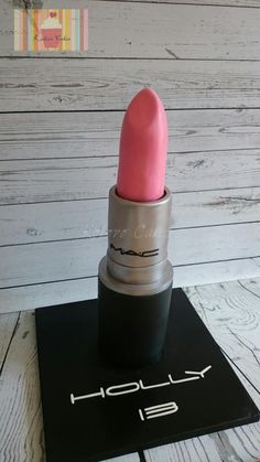 a pink lipstick sitting on top of a black mat