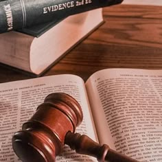 a judge's gavel sitting on top of an open book next to a law book