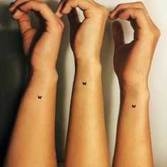 three small tattoos on the arms of two people, one has a butterfly tattoo on it's left arm