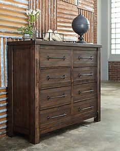 a wooden dresser sitting in front of a brick wall