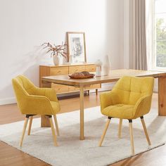 two yellow chairs sitting in front of a wooden table on top of a white rug