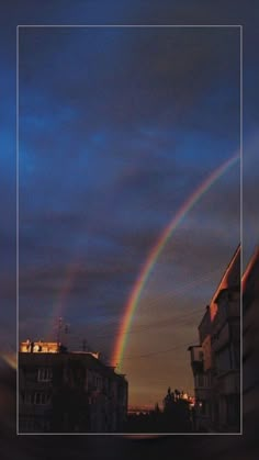 a double rainbow in the sky over some buildings