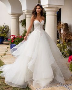 a woman in a wedding dress is standing outside