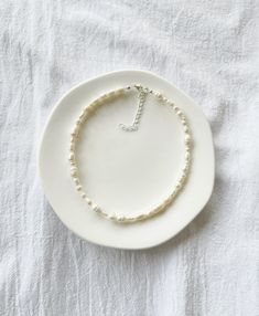 "Photo 2 shows the 16\" length option. Freshwater pearls are one of a kind so each necklace will be entirely unique and will differ from those shown in the photos.  ∙ S I Z E ∙ G U I D E ∙ The below is a rough size guide for adults. We recommend taking your own measurement first before purchasing to ensure the perfect fit, however, exchanges are always welcome - please see our Shop Policies.  14\" - choker length 16\" - collarbone length  18\" to 20\" - upper chest length  20\" to 22\" - chest length Each necklace comes with an additional 2\" extension chain, for example, if you select the 14\" option, the total length of the necklace including the extension chain will be 16\".   M A T E R I A L S ∙    Durable steel cord, genuine freshwater pearls, silver plated or sterling silver clasp an White Pearl Necklaces With Sterling Silver Clasp, Minimalist Single Strand Baroque Pearl Necklace, Adjustable Pearl Necklace With Sterling Silver Clasp, Adjustable Baroque Pearl Necklace In Pearl White, Adjustable Single Strand Baroque Pearl Beaded Necklaces, Adjustable Delicate Baroque Pearl Necklace, White Pearl Necklace With Adjustable Sterling Silver Clasp, Adjustable Baroque Pearl Necklace, Minimalist White Baroque Pearl Necklace