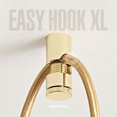 an easy hook is attached to the wall with a gold colored hose connected to it