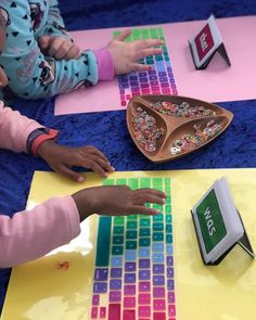 two children are playing with an electronic keyboard and magnets on the table in front of them