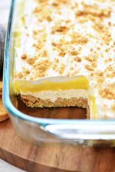 a casserole dish filled with food on top of a wooden cutting board next to crackers